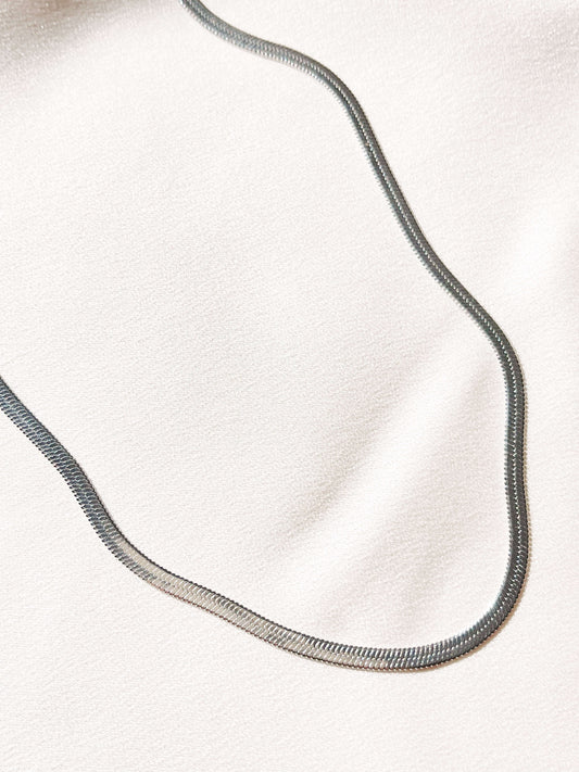 Our classic herringbone chain necklace is a piece we are confident you will love and adore! This sleek and shiny necklace will add a luxurious touch to any look, day or night! If you love wearing necklaces and layering them, this ones an essential piece to add to your collection. Minimalistic, timeless, and elegant, this ones a no-brainer!